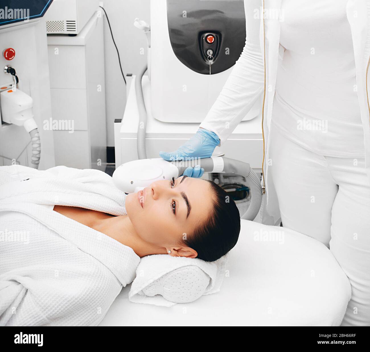 Kosmetikerin entfernt braune Hautflecken im Schönheitssalon. Hautverjüngung einer schönen Frau Stockfoto