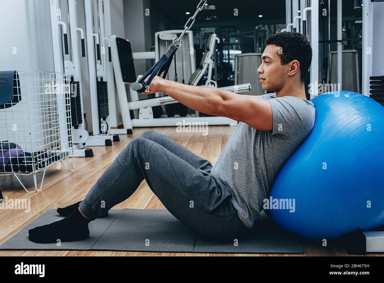 Kinesitherapie, ein gemischter Rennmann trainiert in einem Wellness-Center, auf speziellen Simulatoren Stockfoto