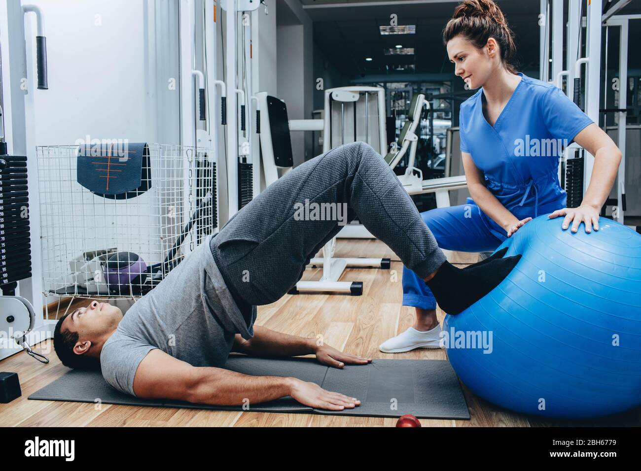 Physiotherapeut hilft bei Übungen ein Mann, ein ehemaliger Militärmann, Behandlung von Verletzungen in einem Militärkrankenhaus. Stockfoto
