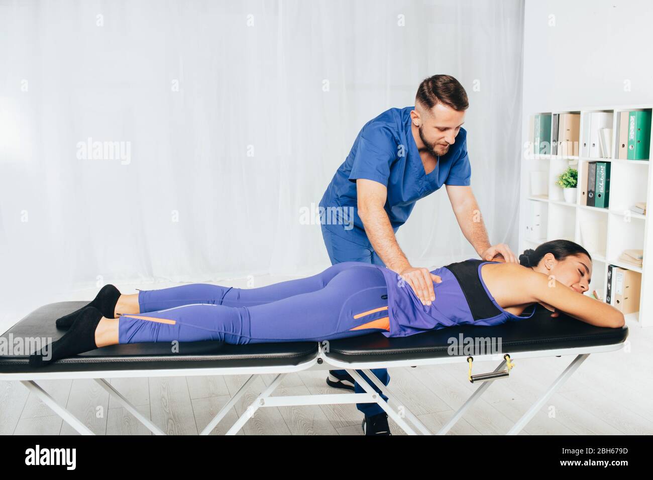 Physiotherapeut massiert Frau zurück, Wirbelbehandlung Stockfoto