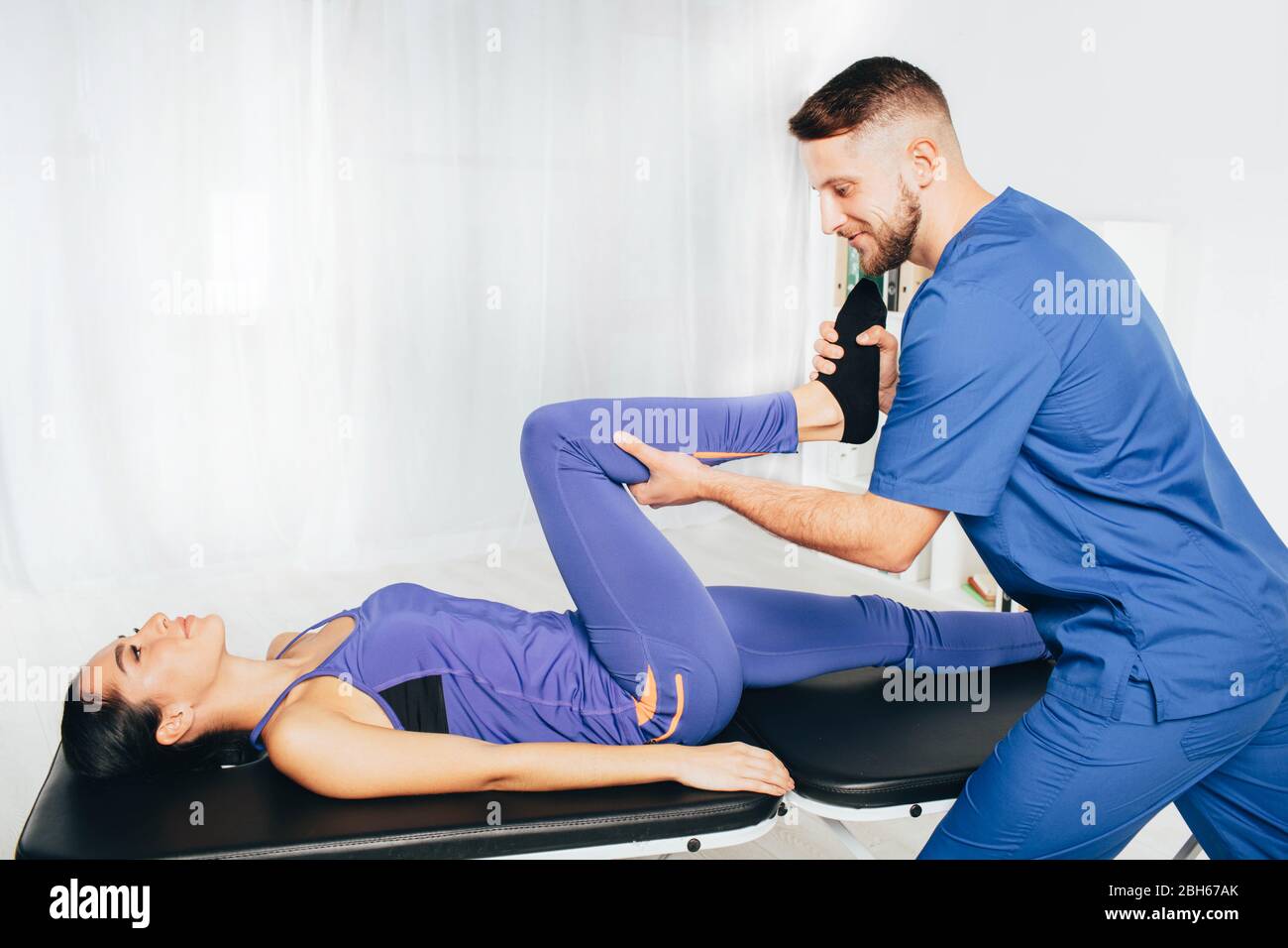 Frau behandelt ihr Gelenk mit Therapeuten. Physiotherapeut hilft seinem Patienten tun Übung für die Behandlung Gelenk Stockfoto