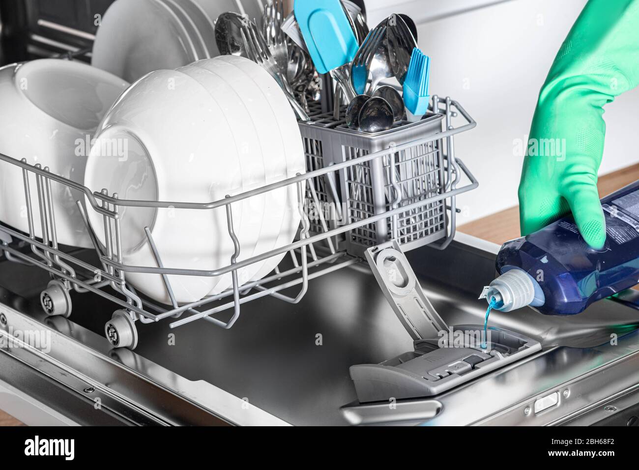 Hausfrau fügen Sie Klarspüler in der Spülmaschine für saubere und glänzende Geschirr, close-up Stockfoto