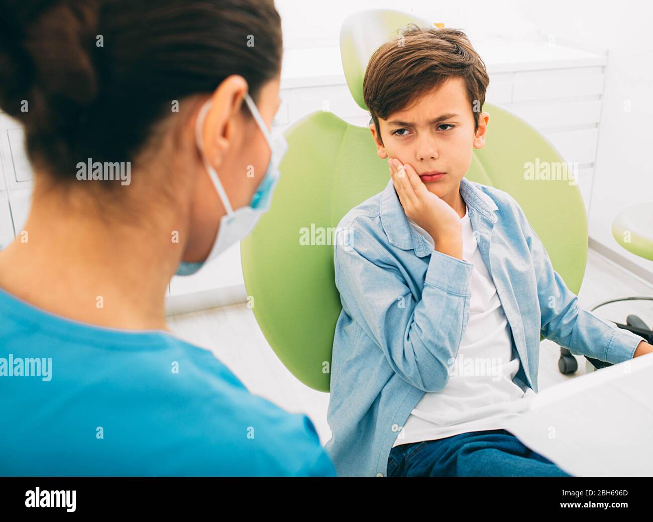 Kleiner Junge mit Zahnschmerzen, die Traurigkeit auf seinem Zahnarzt suchen Stockfoto