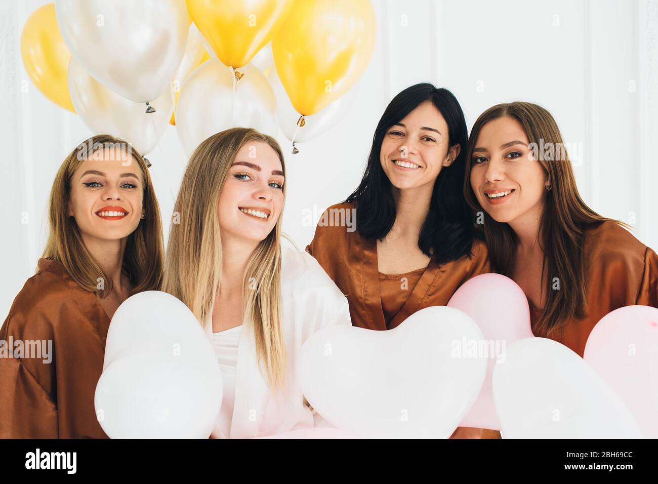 Schöne Freundinnen feiern Geburtstag tragen Satin robes.Women genießen Pyjamas Party Stockfoto