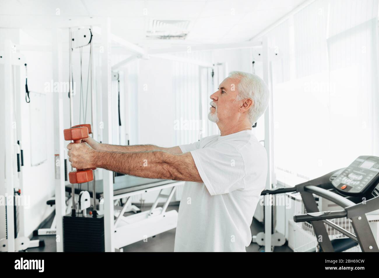 Senior Mann Heben Gewichte in einer Übung Klasse. Gesunde Lebensweise alte Menschen Stockfoto