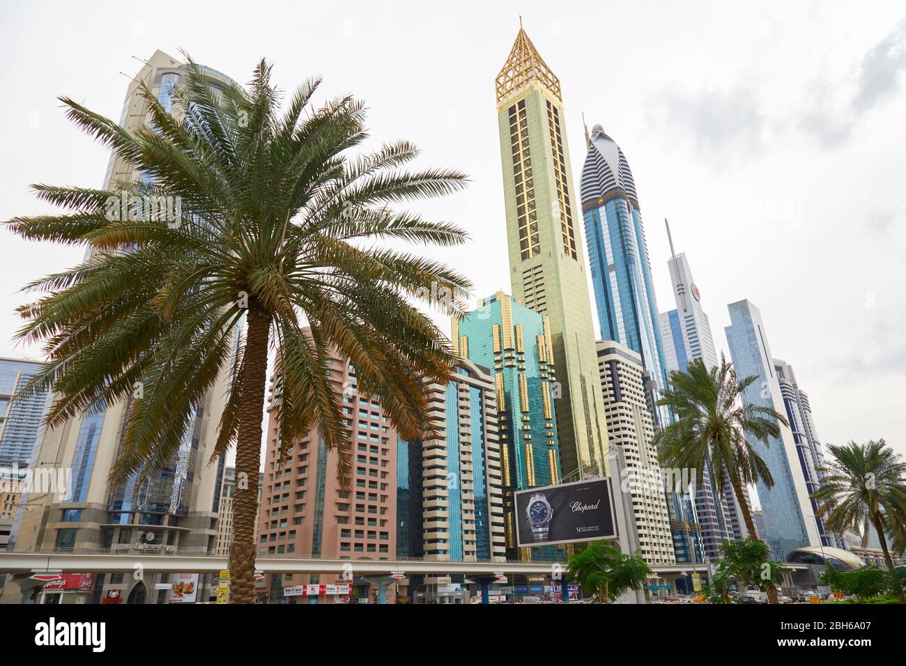 DUBAI, VEREINIGTE ARABISCHE EMIRATE - 21. NOVEMBER 2019: Sheikh Zayed Road aus einem Winkel mit Wolkenkratzern und Palmen in Dubai Stockfoto