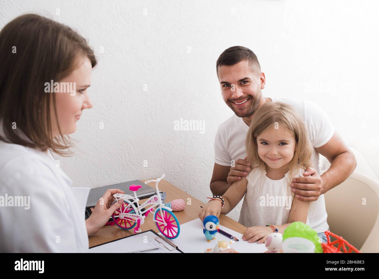 Vater mit seinem Kind beim Kinderpsychologen Büro. Kind Psychologen kümmern sich um die psychische Gesundheit des Kindes Stockfoto