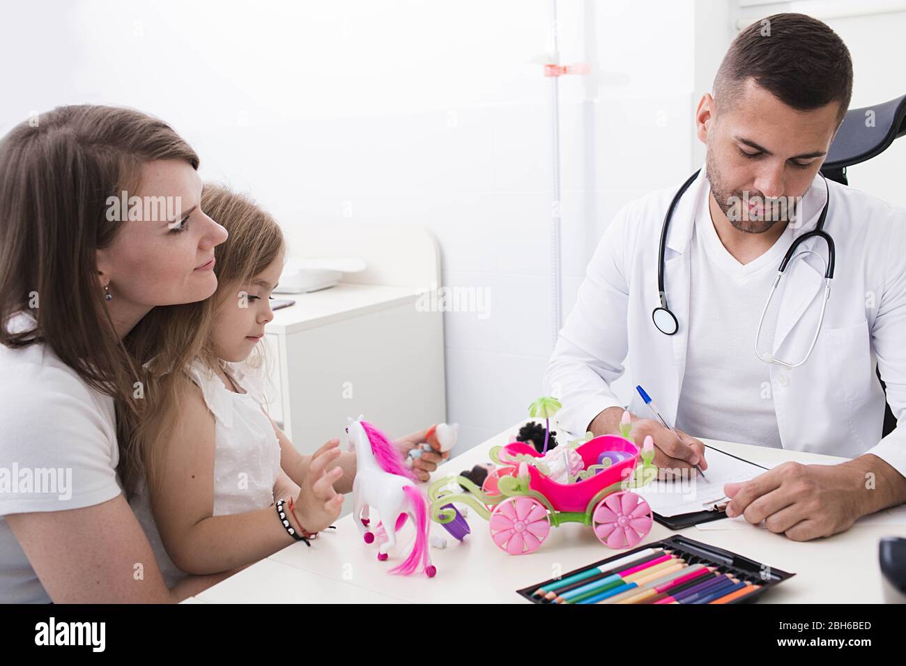 Kinderarzt bei der Arbeit mit einem Kind. Mutter mit einem Kind von einem Kinderarzt untersucht Stockfoto