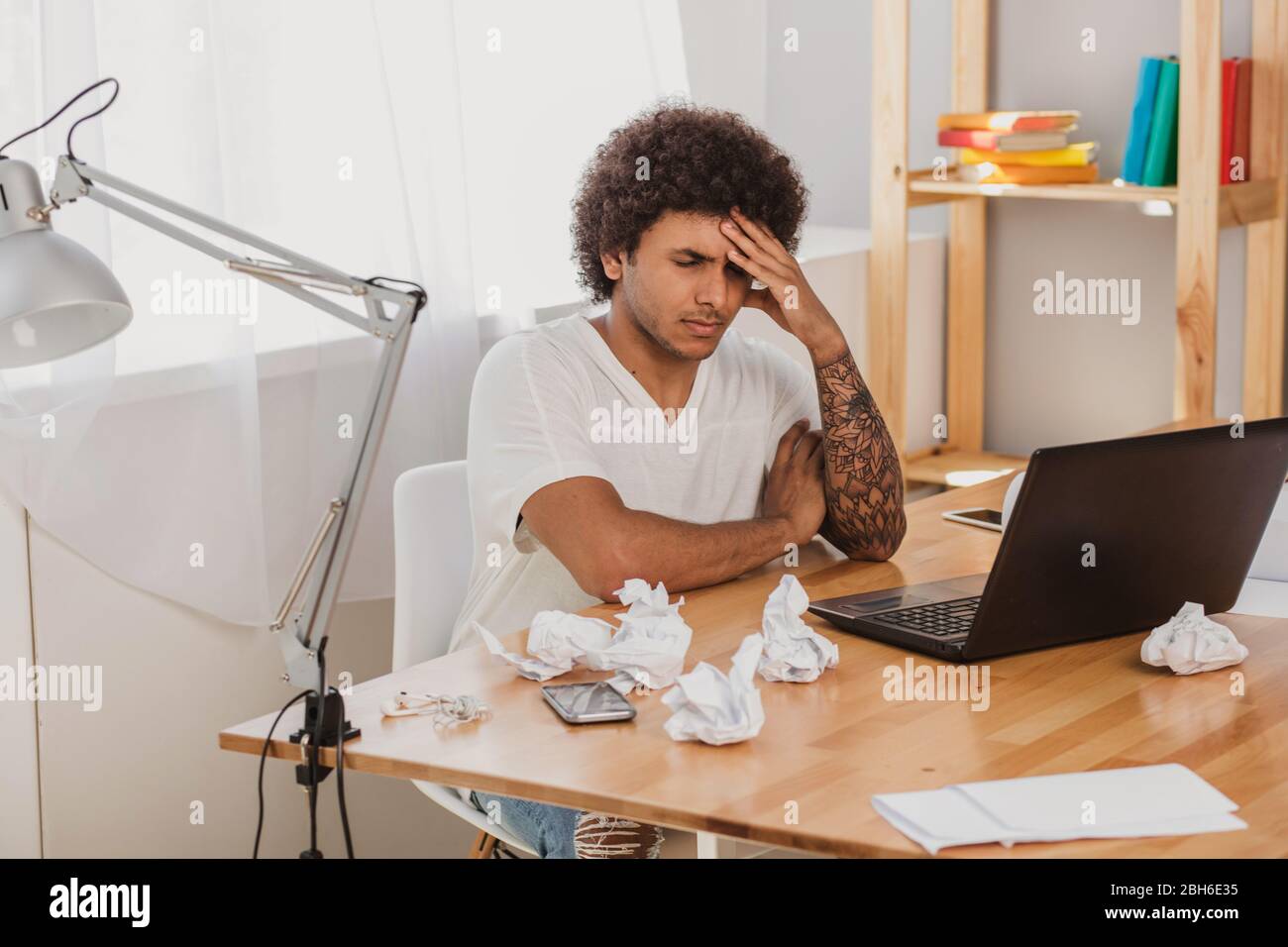 Mulatto junger Mann fühlt sich müde, lehnt seinen Kopf auf die Hand und geschlossenen Augen. Ausfall und Ermüdung der Büroarbeit Stockfoto