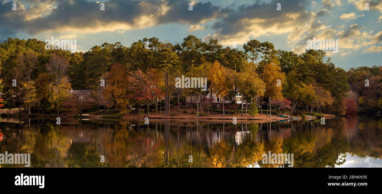 Haus und Bäume am See in der Herbstdämmerung Stockfoto