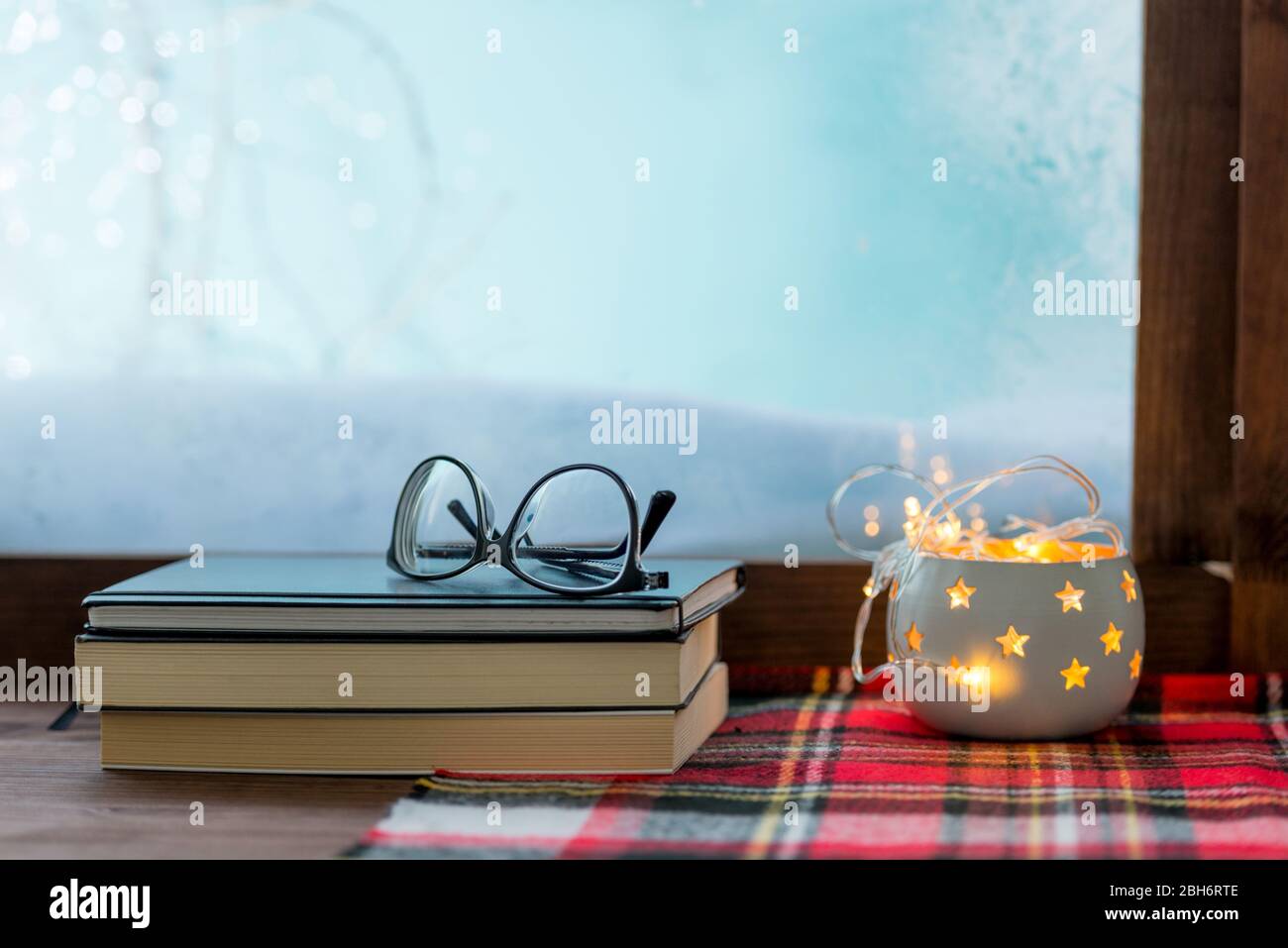 Gemütliche Winterfenster mit Büchern und warmen Decke Hygge Konzept Stockfoto