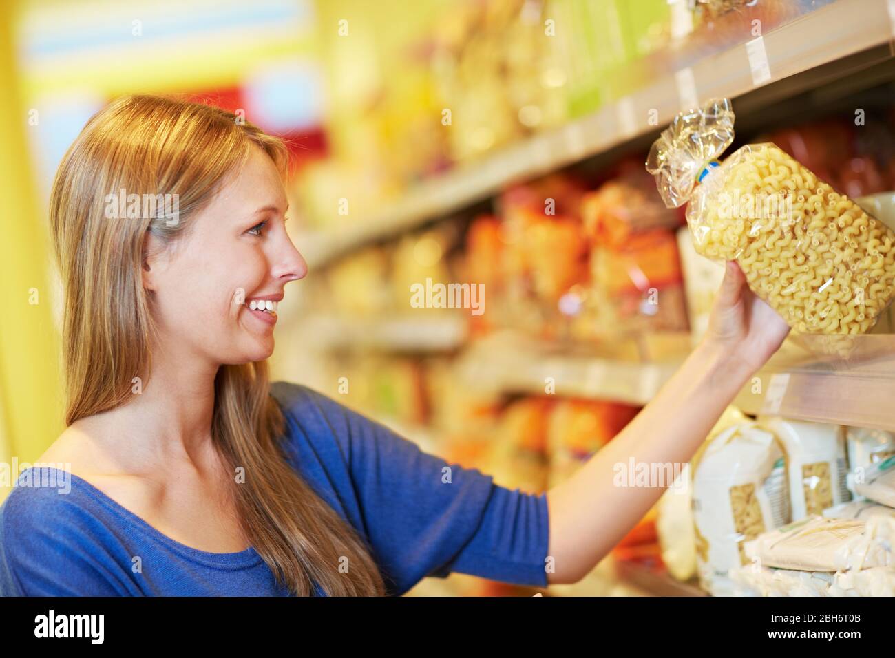 Lächelnde Frau kauft Croissant Nudeln in einem Supermarkt Stockfoto
