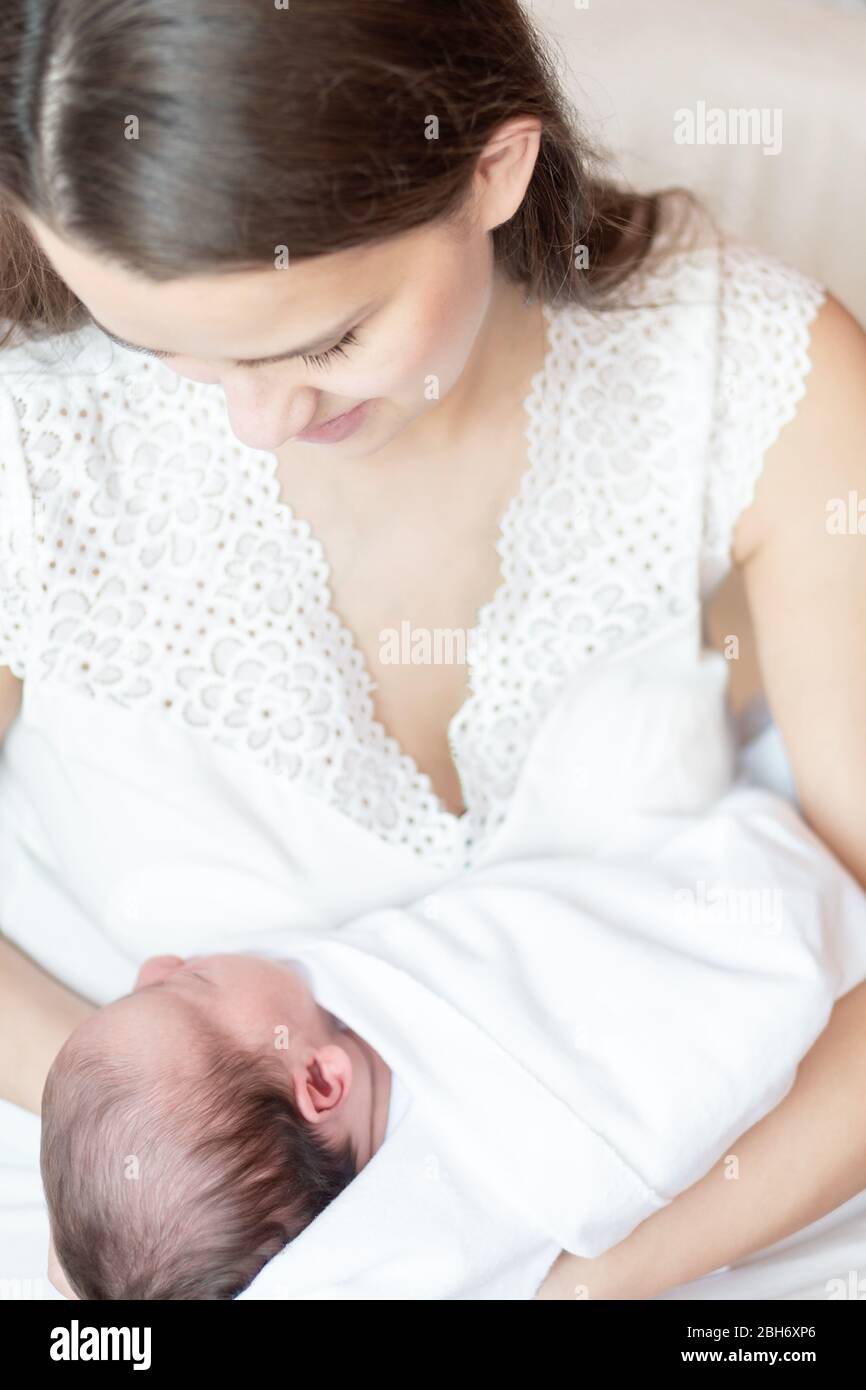 Mutterschaft, Kindheit, Familie, Pflege, Medizin, Schlaf, Gesundheit, Mutterschaft Konzept - Porträt von Mama mit neugeborenem Baby in Windel auf gewickelt Stockfoto