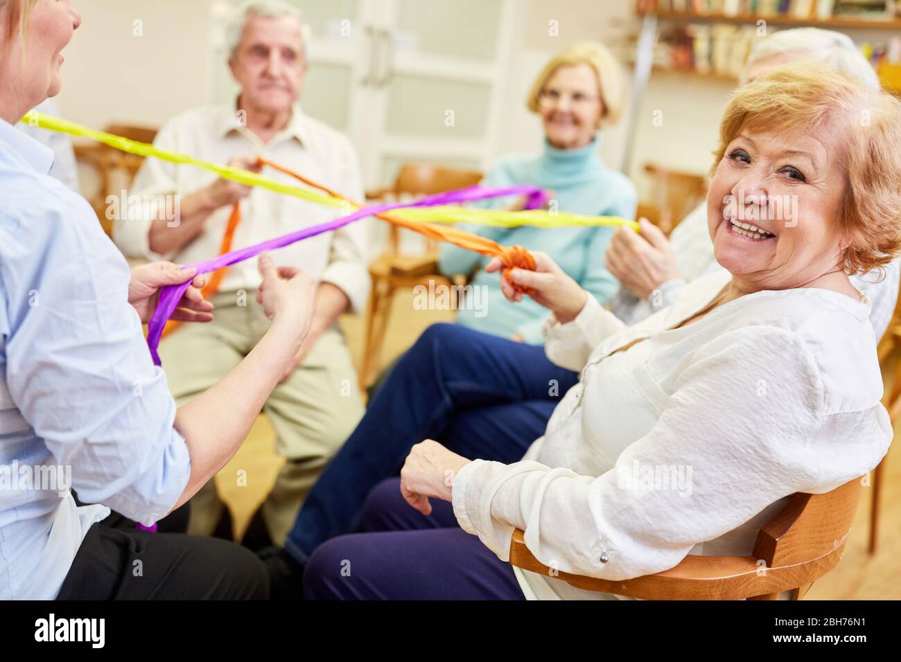 Gruppe von Senioren spielen ein Spiel für Teamgeist und Zusammenhalt in der Altersheim Stockfoto