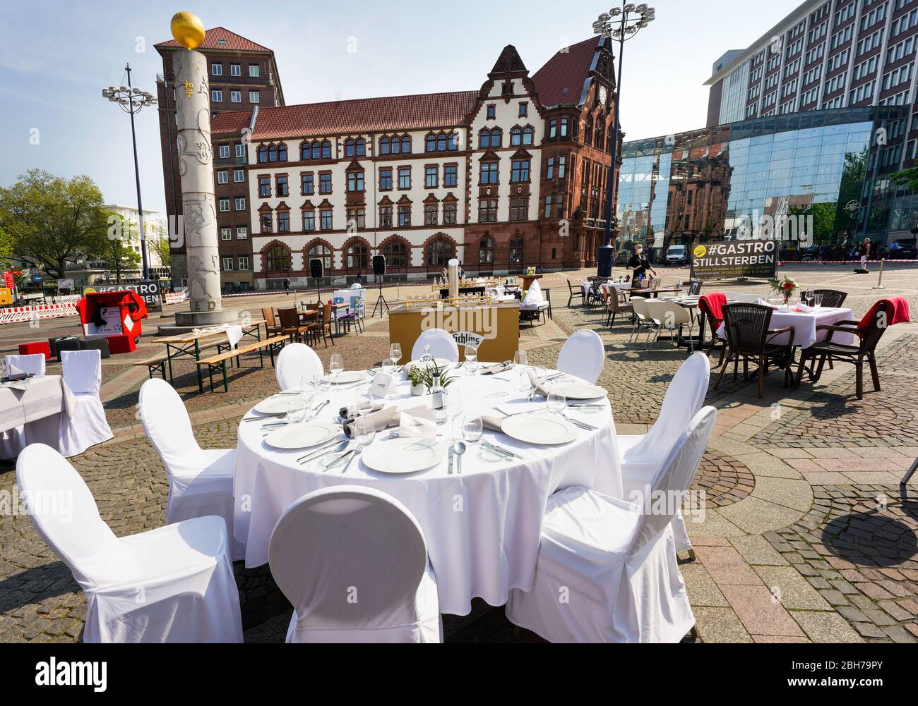 Dortmund, 24.04.2020: Leere Tische, Stühle und Betten auf dem Friedensplatz in Dortmund. Nach einem Aufruf des DEHOGA (Deutscher Hotel- und Gaststättenverband) haben sich Gastronomiebetriebe unter dem Motto STILLSTERBEN zusammengebracht, um an der Protestaktion teilzunehmen, mit der sie auf die Lage ihrer Betriebe auf die Folgen der Corona-Prüfungen in der Corona-Aufmerksam machen. --- Dortmund, 24. April 2020: Leere Tische, Stühle und Betten auf dem Friedensplatz in Dortmund. Nach einem Anruf des Deutschen Hotel- und Restaurantverbandes DEHOGA sind die Gastronomiebetriebe in die Lage gekommen Stockfoto