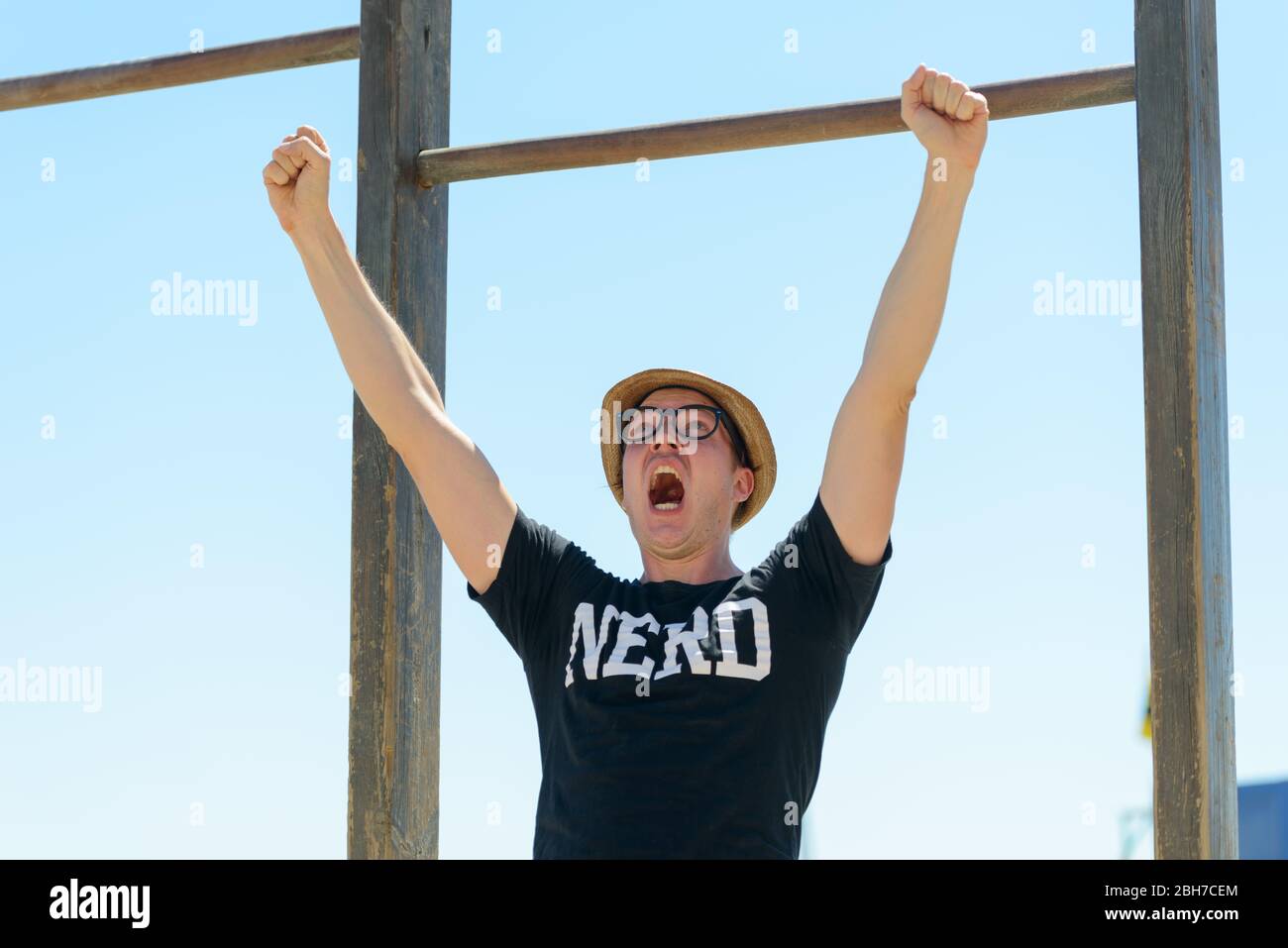 Junger Nerd Tourist Mann immer gute Nachrichten gegen blauen Himmel Stockfoto