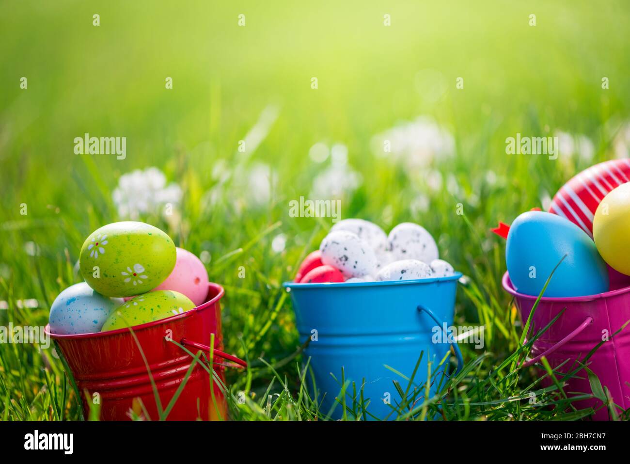 Ostereier im Gras und Blumen Hintergrund Stockfoto