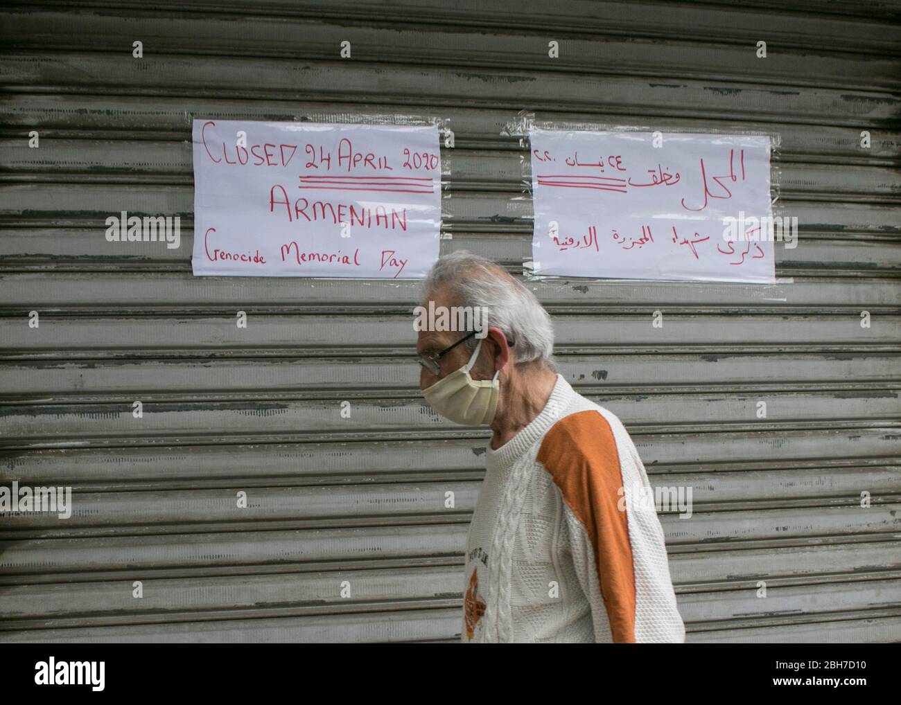 Beirut, Libanon. 24. April 2020. Ein Fußgänger, der eine schützende Gesichtsmask gegen Covid-19 trägt, geht am Gedenktag des armenischen Völkermordes an einem geschlossenen Laden vorbei. Die Türkei lehnt jede Verantwortung ab und hat immer bestritten, dass die Morde Völkermord waren. Kredit: amer Ghazzal/Alamy Live News Stockfoto