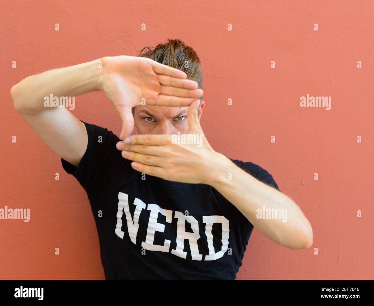 Porträt des jungen schönen Nerd Mann Fokussierung mit Fingerrahmen Geste Stockfoto