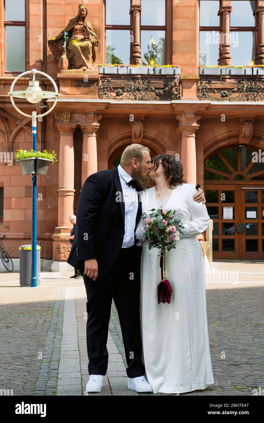 Dortmund, 24. April 2020: Hochzeit in Corona Times. Ein Paar heiratete am 24. April. Vor dem Standesamt gratulierten Familienangehörige und Freunde ihnen im angemessenen Sicherheitsabstand. Stockfoto