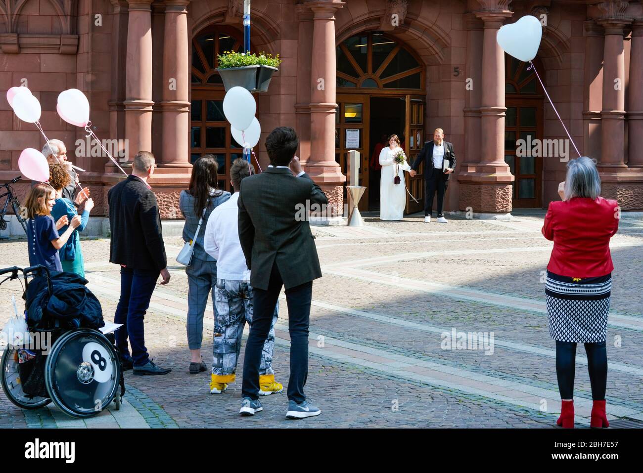 Dortmund, 24. April 2020: Hochzeit in Corona Times. Ein Paar heiratete am 24. April. Vor dem Standesamt gratulierten Familienangehörige und Freunde ihnen im angemessenen Sicherheitsabstand. Stockfoto
