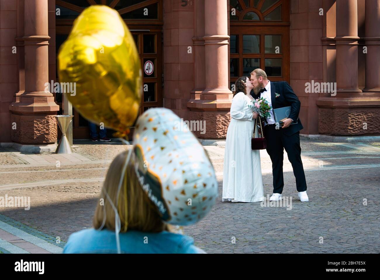 Dortmund, 24. April 2020: Hochzeit in Corona Times. Ein Paar heiratete am 24. April. Vor dem Standesamt gratulierten Familienangehörige und Freunde ihnen im angemessenen Sicherheitsabstand. Stockfoto