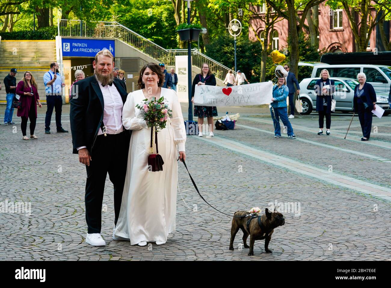 Dortmund, 24. April 2020: Hochzeit in Corona Times. Ein Paar heiratete am 24. April. Vor dem Standesamt gratulierten Familienangehörige und Freunde ihnen im angemessenen Sicherheitsabstand. Stockfoto