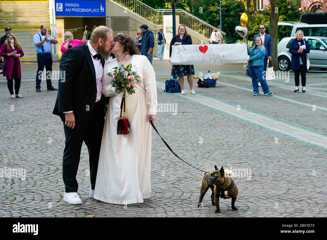 Dortmund, 24. April 2020: Hochzeit in Corona Times. Ein Paar heiratete am 24. April. Vor dem Standesamt gratulierten Familienangehörige und Freunde ihnen im angemessenen Sicherheitsabstand. Stockfoto