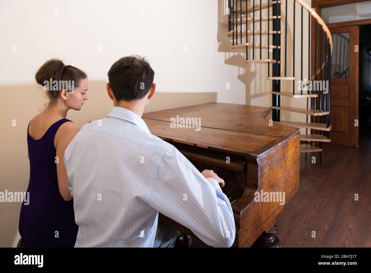 Forte Klavier mit jungen Frau Mann romantischen Paar im Zimmer Pianist in formellen Kleid im Zimmer für ein Konzert zusammen spielen Stockfoto