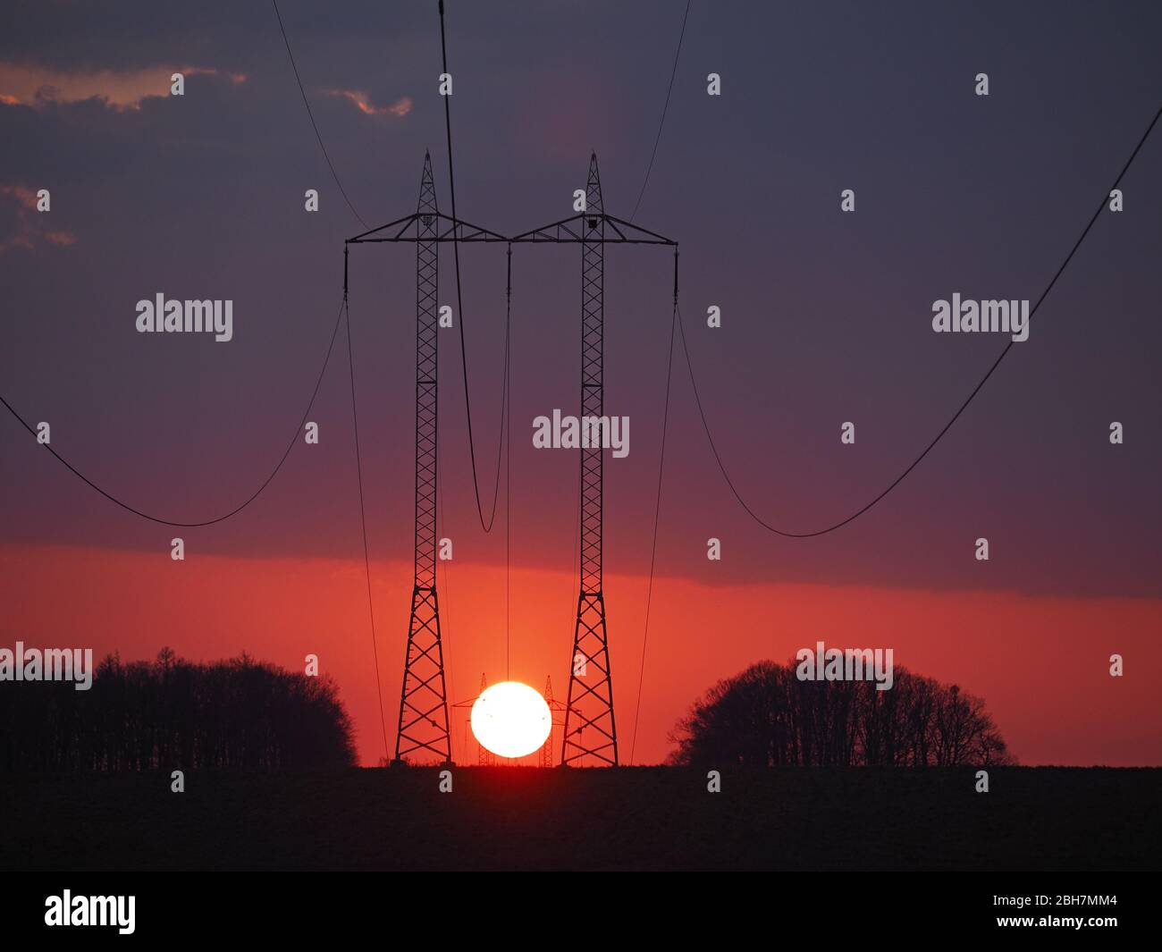 Zwei Türme mit Hochspannung während des Sonnenuntergangs Stockfoto