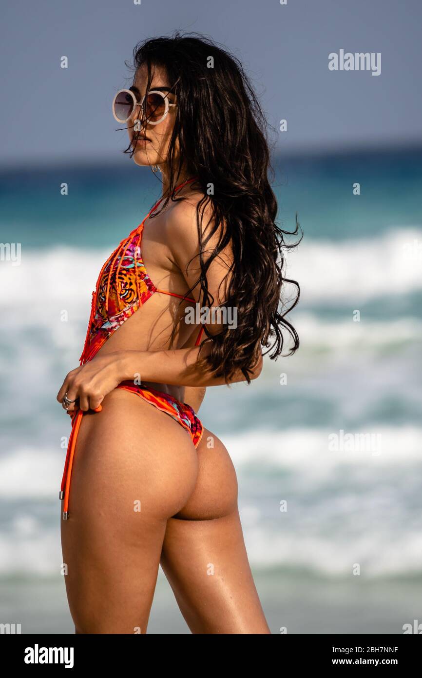 Ziemlich junges hispanischer Model, das eine gute Zeit am Strand am Meer hat. Stockfoto