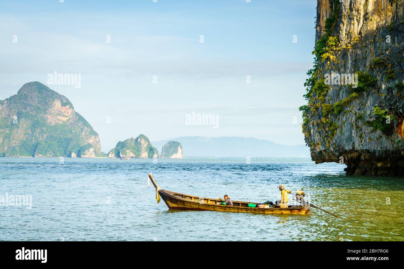 Traditionelles thailändisches Motorboot in der Andamanensee mit Phuket Küste im Hintergrund Stockfoto