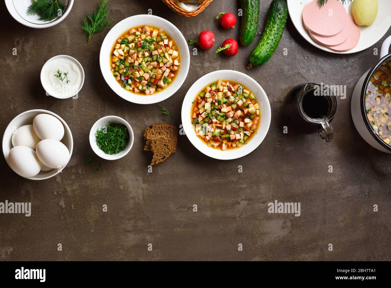 Sommer kalte russische Suppe Okroshka mit Wurst, Gemüse und Kvass über braunen Stein Hintergrund mit freiem Text Raum. Draufsicht, flaches Lay Stockfoto