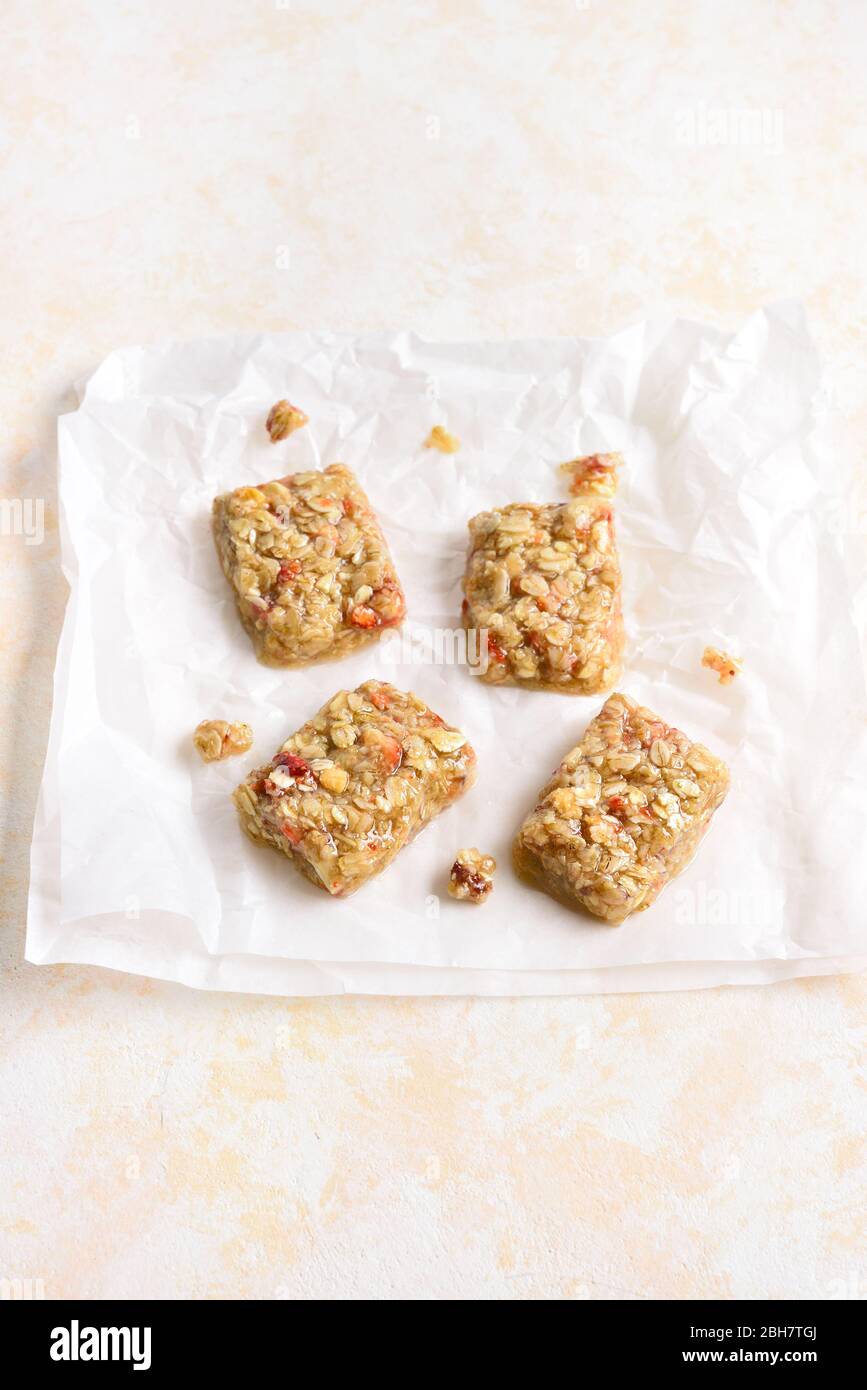 Honig keine gebackene Müsliriegel auf Papier über hellem Stein Hintergrund mit freiem Platz. Natürlicher gesunder Snack. Stockfoto