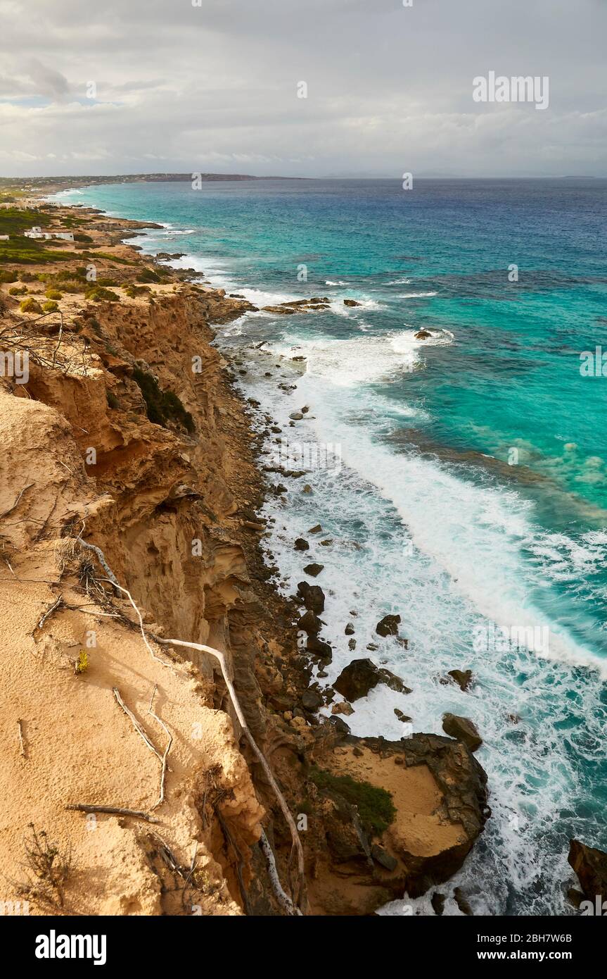 Es Carnatge Klippen und Küste mit blauem rauem Wasser in der Nähe von Es Caló de Sant Agustí (Formentera, Pityuses, Balearen, Mittelmeer, Spanien) Stockfoto
