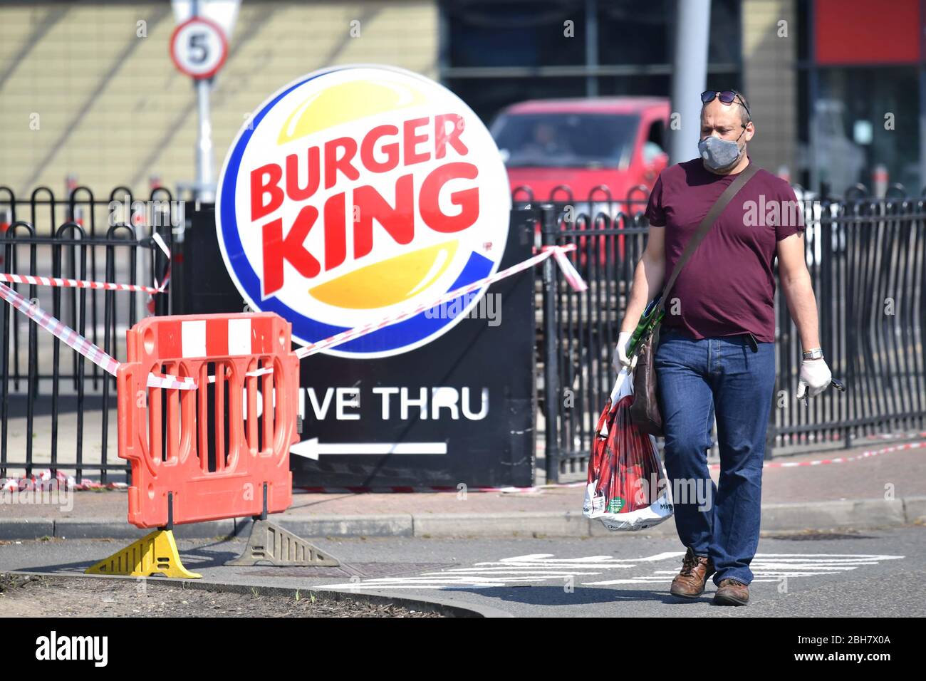 Ein Mann geht an einem geschlossenen Burger King im Tottenham Hale Retail Park in London vorbei, während Großbritannien weiterhin in der Sperre bleibt, um die Ausbreitung des Coronavirus einzudämmen. Stockfoto