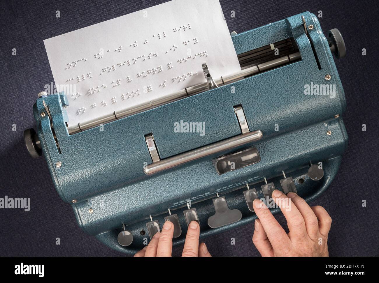 Eine Frau, die mit einer Schreibmaschine Perkins Brailler in Braille schreibt. Stockfoto