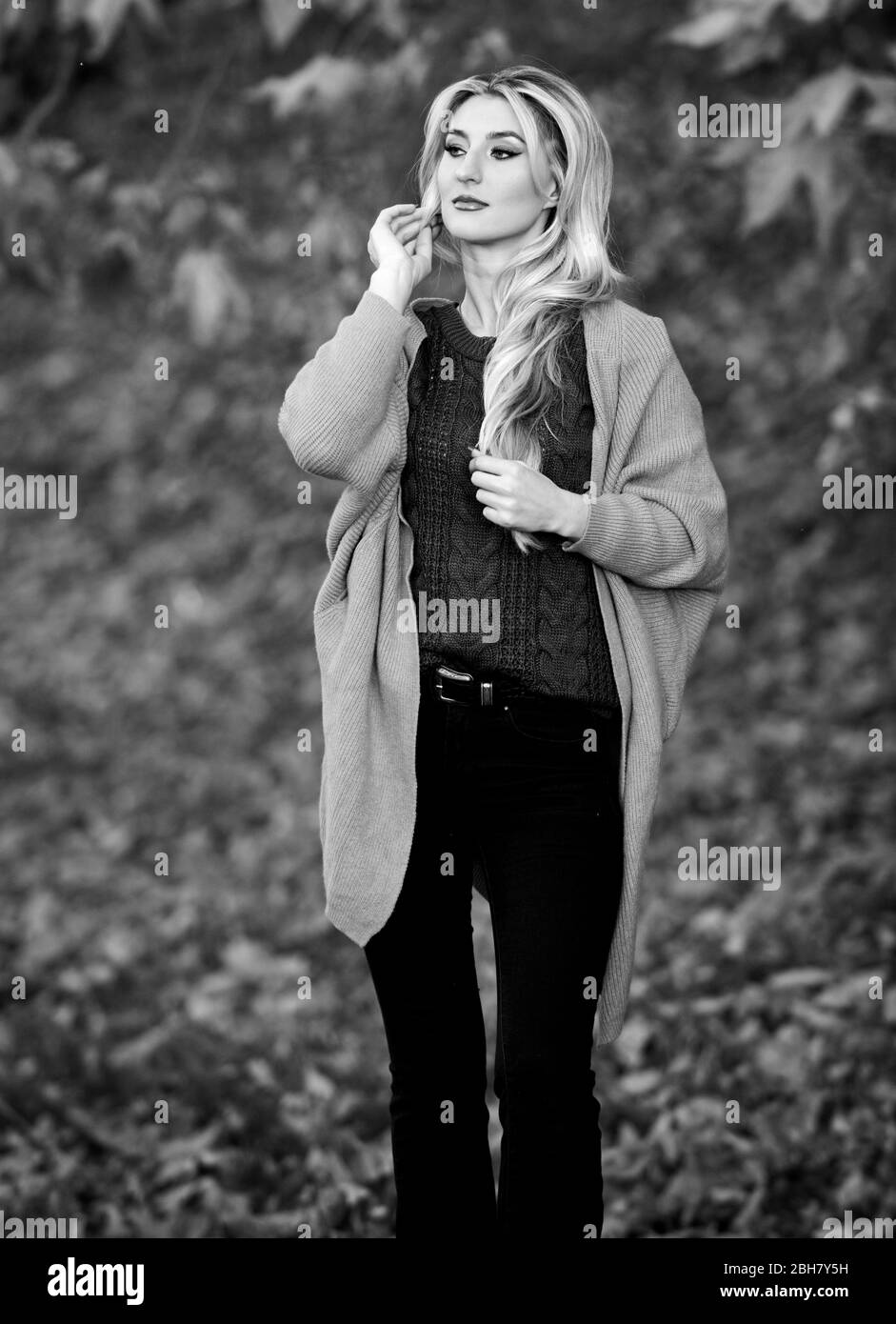 Mädchen liebenswert blond posiert in warmen und gemütlichen Outfit Herbst Natur Hintergrund defokussieren. Kuschelige Outfit Ideen für das Wochenende. Frau gehen Sonnenuntergang Licht. Kleidung für jeden Tag. Kuschelige Freizeitoutfits für den Herbst. Stockfoto