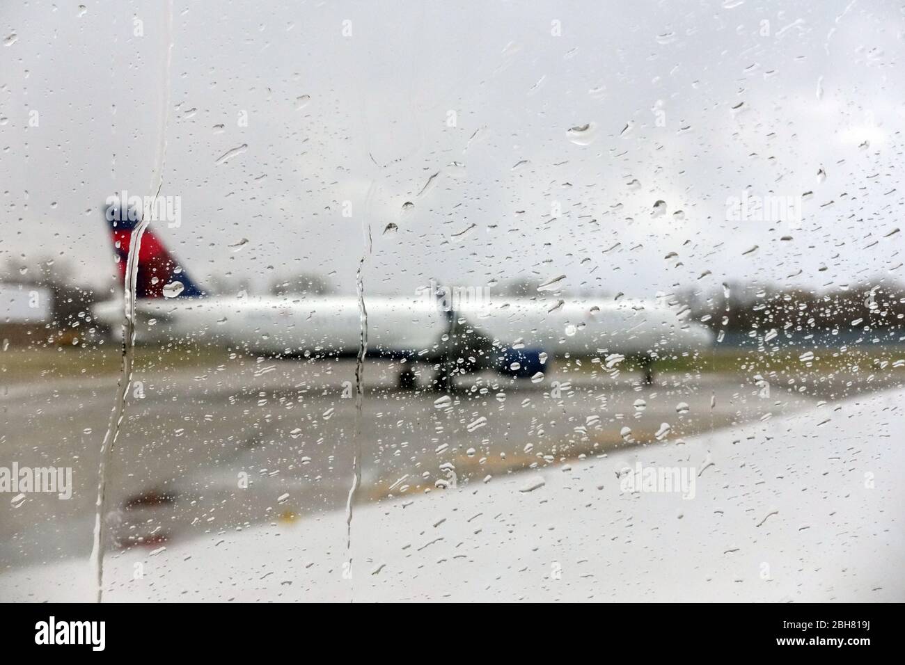 09.04.2020, Minneapolis, Minnesota, USA - Delta Airlines Flugzeuge schimmern durch eine mit Regentropfen benetzte Fensterscheibe. 00S200409D262CAROEX.JPG [MOD Stockfoto