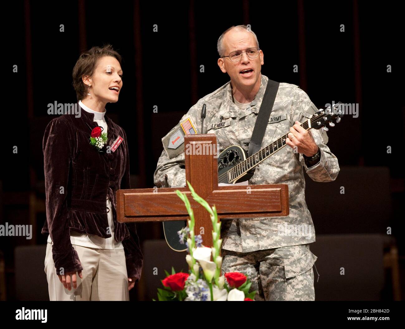 Killeen, Texas, USA, 8. November 2009: Kaplan Michael T. Lembke (r) vom III. Korps von Fort Hood und seine Tochter Heidi (l) singen drei Tage nach der Eröffnung des Feuers im nahe gelegenen Fort Hood bei einem Gedenkgottesdienst in der First Baptist Church of Killeen, nachdem der Angeklagte Schütze Nidal Hasan 13 Menschen getötet und viele weitere verletzt hatte. ©Bob Daemmrich Stockfoto