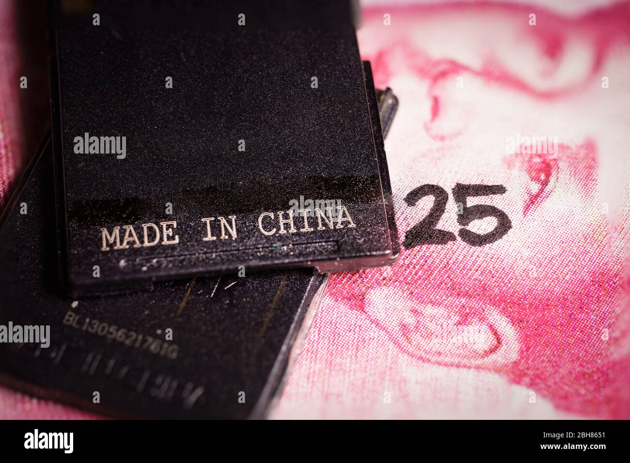 In china gemachter Text auf einem Stück Plastik über einem Yuan-Schein. Stockfoto