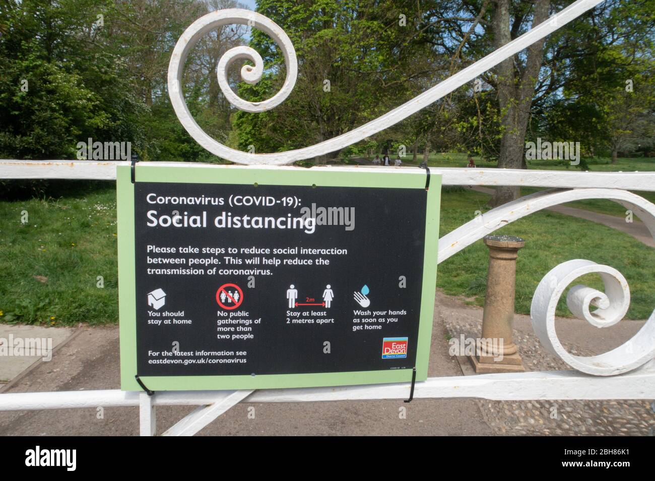 Soziale Distanzierungszeichen, die vom EDDC des East Devon District Council am Eingang zum Mauthaus-Tor zum Byes Park, Sidmouth, Devon, angebracht wurden. Stockfoto