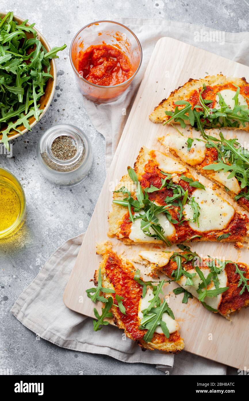 Hausgemachte glutenfreie Cauliflower Pizza Kruste Teig mit Tomaten Marinara-Sauce, Mozzarella-Käse für Low-Carb und Keto Ernährung.Draufsicht Stockfoto