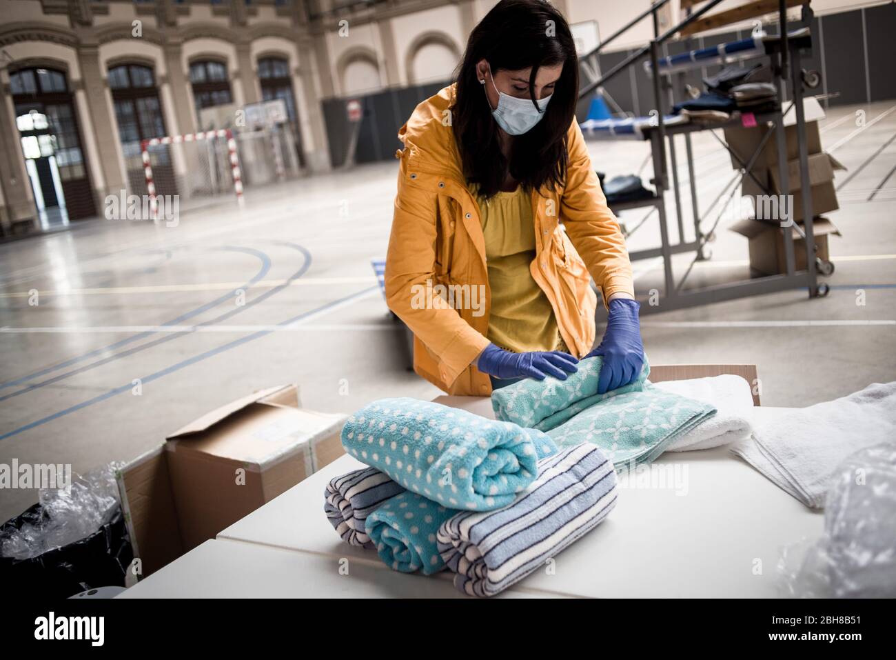 24. April 2020, Barcelona, Katalonien, Spanien - die Sozialarbeiterin Monica faltet Handtücher an einem Lebensmittel- und Bekleidungsverteilungspunkt in einem Sportkomplex von Barcelona, um die Bevölkerung mit wirtschaftlichen Problemen aufgrund der Pandemiekrise zu unterstützen. Spanien schlägt einen 1.5 Billionen Euro schweren Coronavirus-Rückgewinnungsfonds vor, der durch die unbefristete EU-Verschuldung finanziert wird. Die Europäische Union wird einen Rückgewinnungsfonds einrichten, der verschiedenen Ländern helfen soll, aus der Wirtschaftskrise, die durch die Coronavirus-Pandemie verursacht wurde, herauszukommen. Quelle: Jordi Boixareu/Alamy Live News Stockfoto