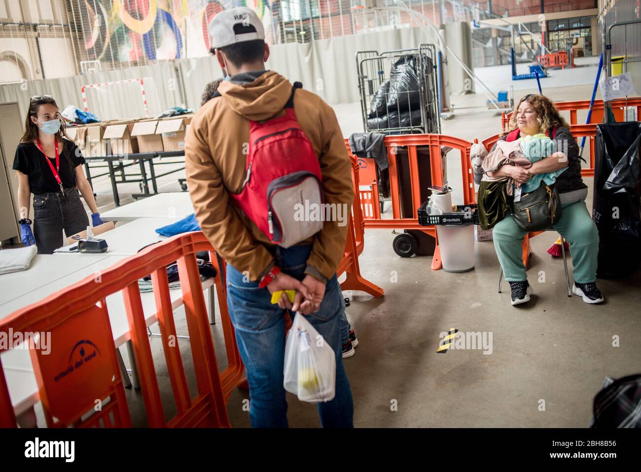 24. April 2020, Barcelona, Katalonien, Spanien - die Sozialarbeiterin Anna (L) besucht die Nutzer an einem Lebensmittel- und Bekleidungsverteilungsort, der in einem Sportkomplex von Barcelona installiert wurde, um die Bevölkerung bei wirtschaftlichen Problemen aufgrund der Pandemiekrise zu unterstützen. Spanien schlägt einen 1.5 Billionen Euro schweren Coronavirus-Rückgewinnungsfonds vor, der durch die unbefristete EU-Verschuldung finanziert wird. Die Europäische Union wird einen Rückgewinnungsfonds einrichten, der verschiedenen Ländern helfen soll, aus der Wirtschaftskrise, die durch die Coronavirus-Pandemie verursacht wurde, herauszukommen. Quelle: Jordi Boixareu/Alamy Live News Stockfoto