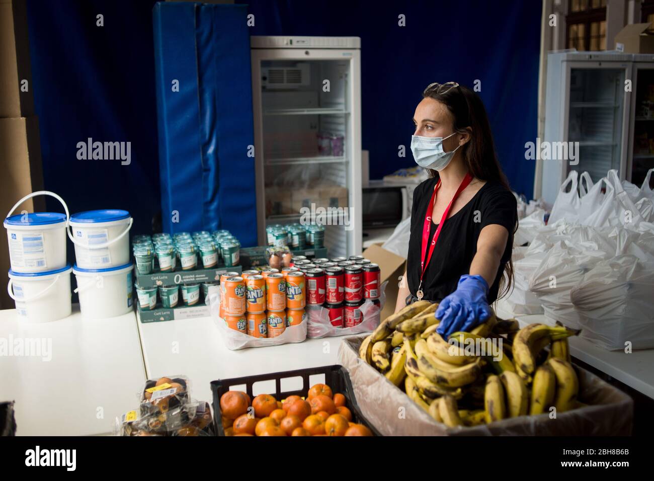 24. April 2020, Barcelona, Katalonien, Spanien - Sozialarbeiterin Anna an einem Lebensmittel- und Bekleidungsverteilungsort in einem Sportkomplex von Barcelona installiert, um die Bevölkerung mit wirtschaftlichen Problemen aufgrund der Pandemiekrise zu unterstützen. Spanien schlägt einen 1.5 Billionen Euro schweren Coronavirus-Rückgewinnungsfonds vor, der durch die unbefristete EU-Verschuldung finanziert wird. Die Europäische Union wird einen Rückgewinnungsfonds einrichten, der verschiedenen Ländern helfen soll, aus der Wirtschaftskrise, die durch die Coronavirus-Pandemie verursacht wurde, herauszukommen. Quelle: Jordi Boixareu/Alamy Live News Stockfoto
