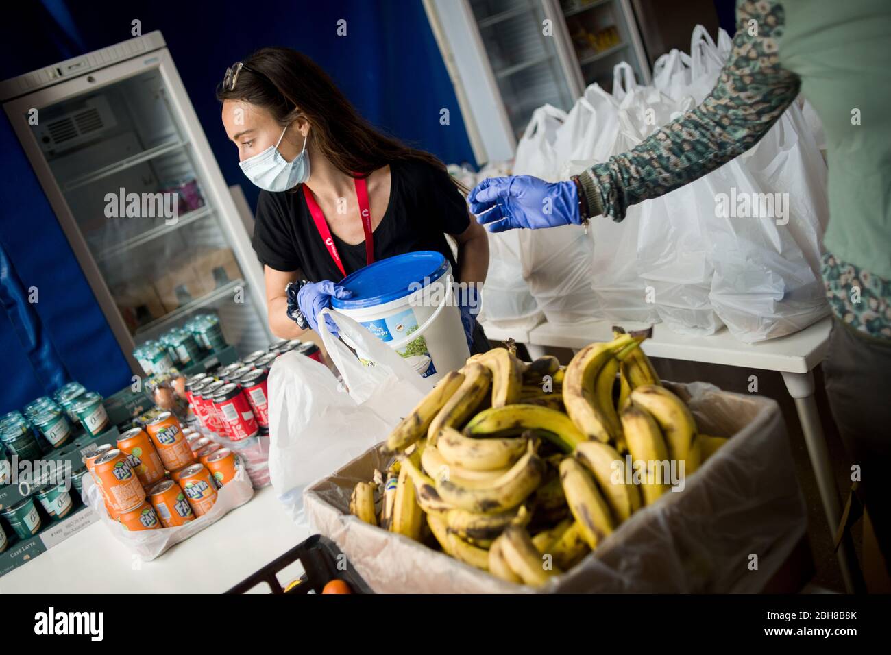 24. April 2020, Barcelona, Katalonien, Spanien - Sozialarbeiterin Anna an einem Lebensmittel- und Bekleidungsverteilungsort in einem Sportkomplex von Barcelona installiert, um die Bevölkerung mit wirtschaftlichen Problemen aufgrund der Pandemiekrise zu unterstützen. Spanien schlägt einen 1.5 Billionen Euro schweren Coronavirus-Rückgewinnungsfonds vor, der durch die unbefristete EU-Verschuldung finanziert wird. Die Europäische Union wird einen Rückgewinnungsfonds einrichten, der verschiedenen Ländern helfen soll, aus der Wirtschaftskrise, die durch die Coronavirus-Pandemie verursacht wurde, herauszukommen. Quelle: Jordi Boixareu/Alamy Live News Stockfoto