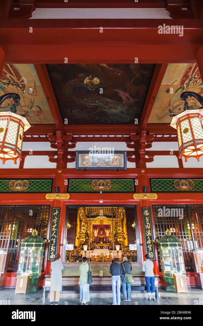 Japan, Honshu, Tokyo, Asakusa, Sensoji-tempel, Personen innerhalb der Haupthalle Beten Stockfoto