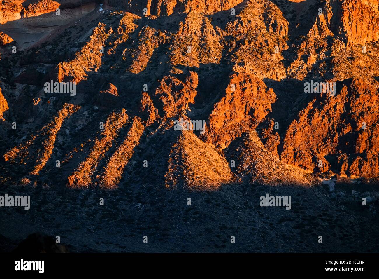 Warmer Sonnenuntergang auf den felsigen Bergen in El teide teneriffa. Schöne Tapete mit Halterungen rot und orange und Schatten Stockfoto