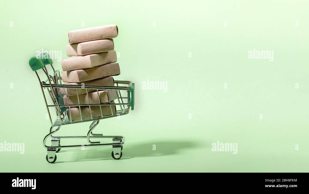 Mini-Shopping-Trolley mit Stapel von verpackten Boxen. Hellgrüne Neo-Minze-Kulisse. Platz für Text kopieren. Konzept sicher, kontaktlos Lieferung während pand Stockfoto